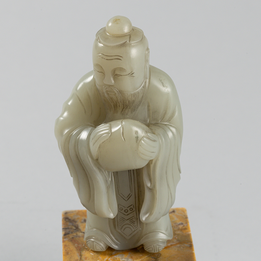 Lot2010 A PALE CELADON JADE FIGURE OF A DONGFANG SHUO(東方朔) QING DYNASTY(17TH TO 18TH CENTURY)